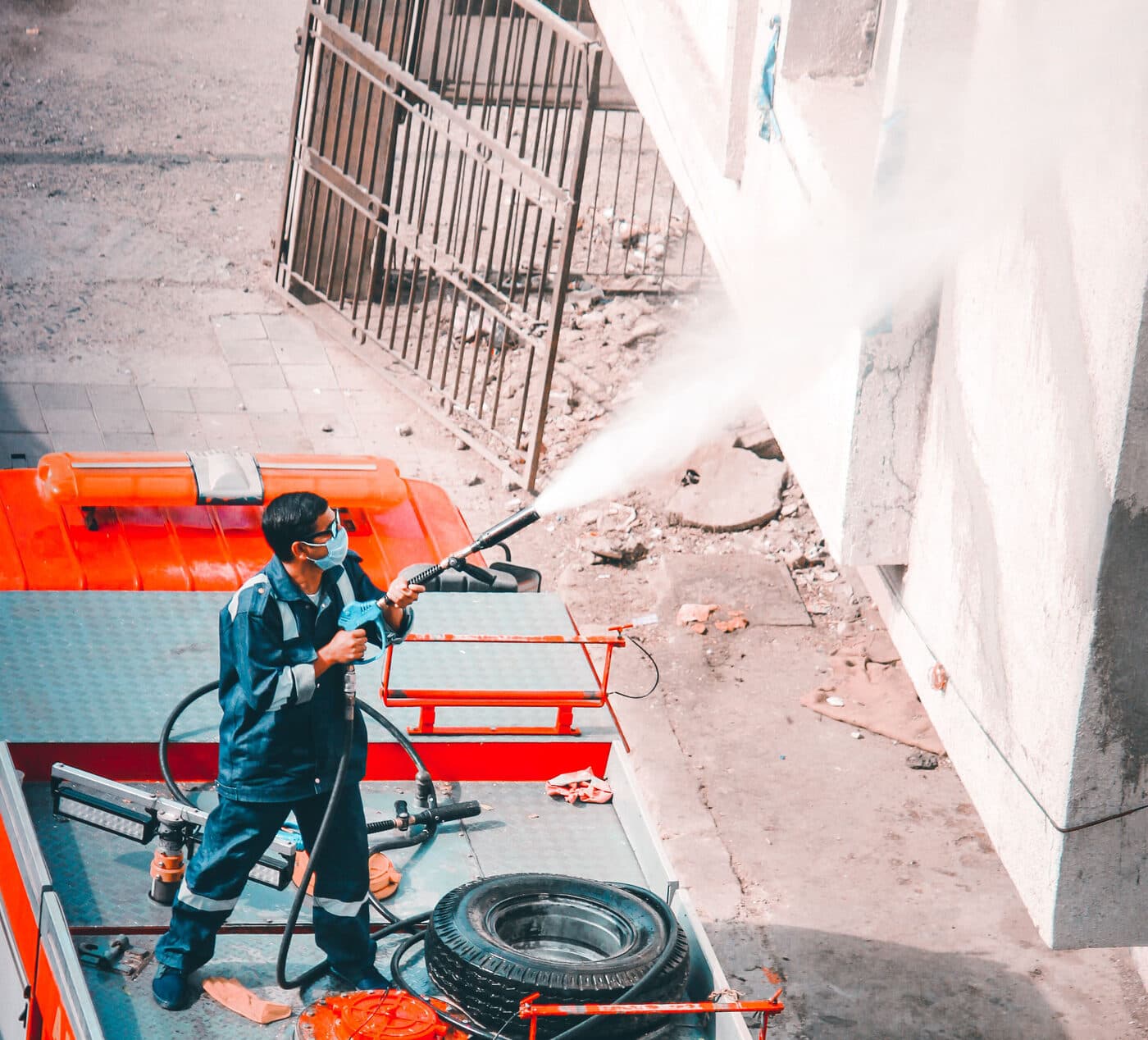 Crew soft washing an exterior wall with low pressure equipment