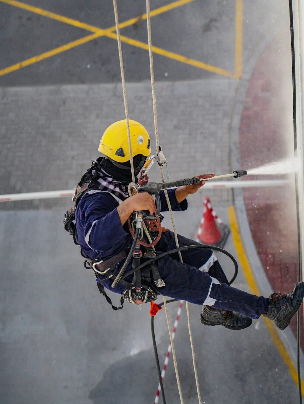 Technicians cleaning a building exterior at height